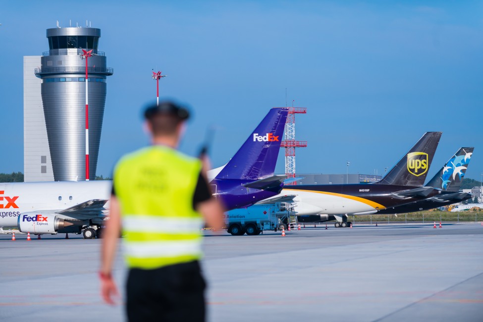 lotnisko w Katowicach: pracownik terminalu cargo z kilkoma samolotami cargo w tle 