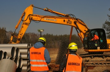 koparka i dwóch geodetów 