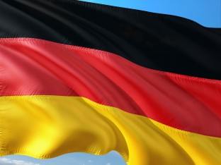 flaga niemiecka (kolor czarny, czerwony i żółoty) na tle błękitnego nieba 